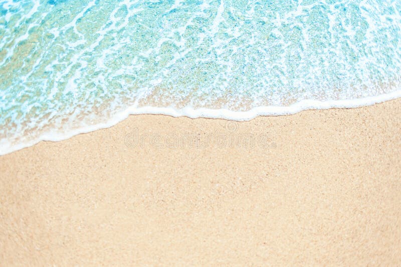 Soft waves with foam blue ocean sea on golden sand with copyspace. Summer beach vacations background. Soft waves with foam blue ocean sea on golden sand with copyspace. Summer beach vacations background