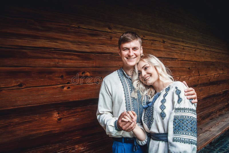 Zadziwiająca ślub para uśmiecha się ręki na tle drewniany dom i trzyma fotografia stock Zadziwiająca ślub para uśmiecha się ręki na tle drewniany dom i trzyma fotografia stock