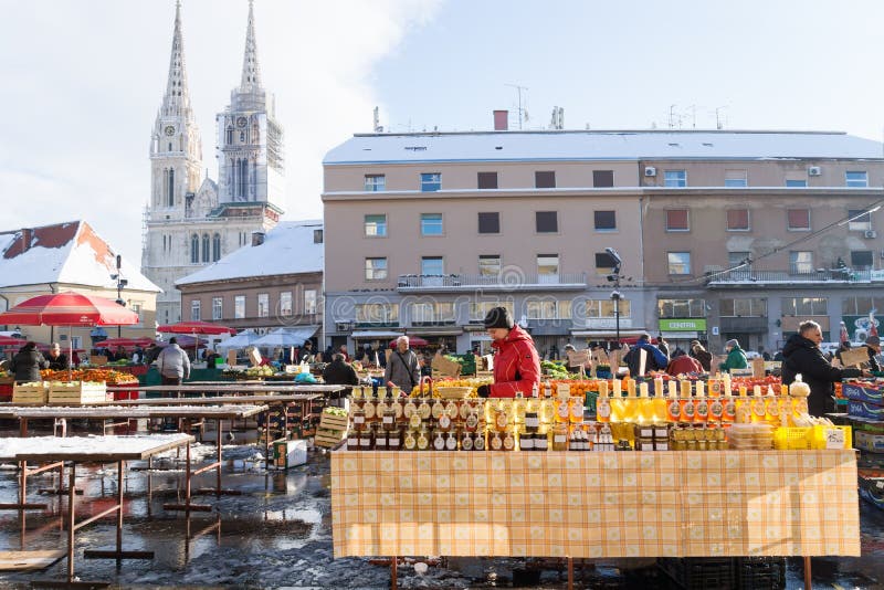 Zagreb, Croatia: January 7 2016: Stand with honey glasses at Dolac market during wintertime with snow with cathedral in the back stock images Zagreb, Croatia: January 7 2016: Stand with honey glasses at Dolac market during wintertime with snow with cathedral in the back stock images