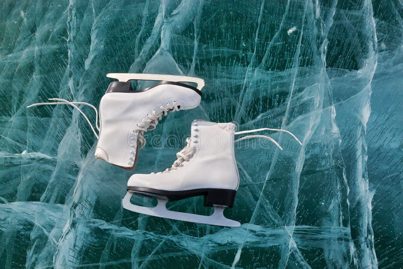 Figure skates at transparent cracked ice surface close up. Winter sport concept. Lake Baikal ice. Figure skates at transparent cracked ice surface close up. Winter sport concept. Lake Baikal ice.