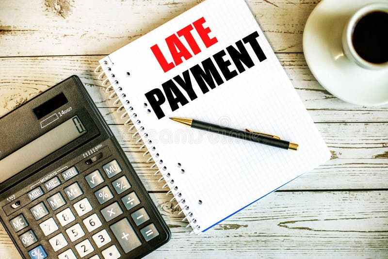 LATE PAYMENT written on white paper near coffee and calculator on a light wooden table. Business concept. LATE PAYMENT written on white paper near coffee and calculator on a light wooden table. Business concept.