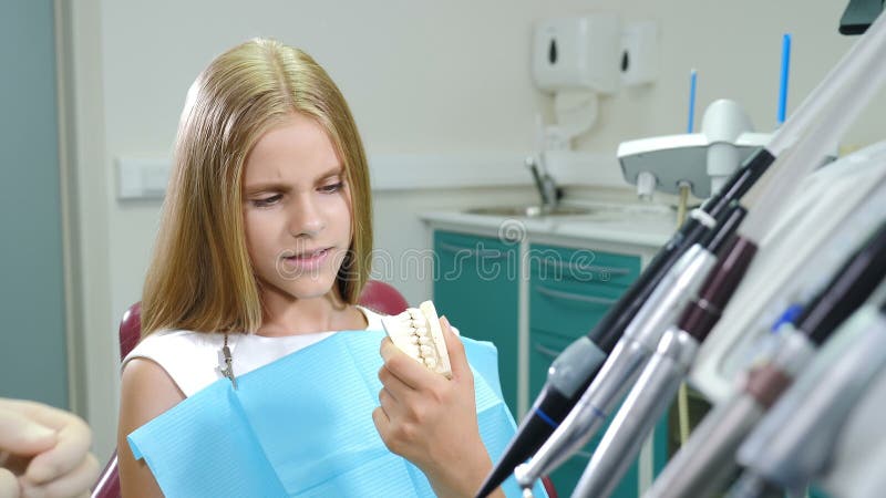 Zahnarzt zeigt kleinen Mädchen-Kiefer-Modell bei Zahnarztbüro Zahnbehandlung im Zahnstuhl in der Klinik sitzen stock video