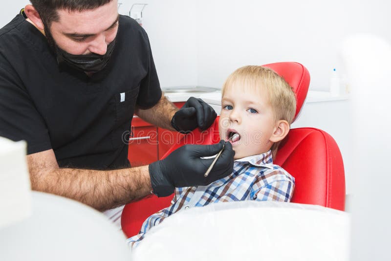 Zahnmedizinische Klinik Aufnahme, Pr?fung des Patienten Zahnsorgfalt Zahnarzt, der Z?hne des kleinen Jungen im Zahnarztb?ro behan stockfoto Zahnmedizinische Klinik Aufnahme, Pr?fung des Patienten Zahnsorgfalt Zahnarzt, der Z?hne des kleinen Jungen im Zahnarztb?ro behan stockfoto