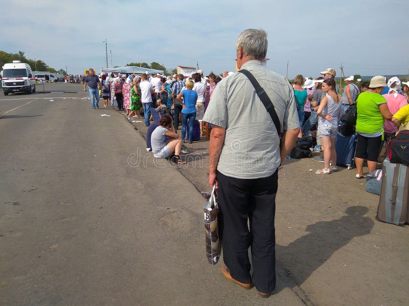 Zaitseva, Ucraina - 22 agosto 2016: La gente sta nella linea all'intersezione del controllo nell'area dell'operazione antiterrori immagine stock libera da diritti