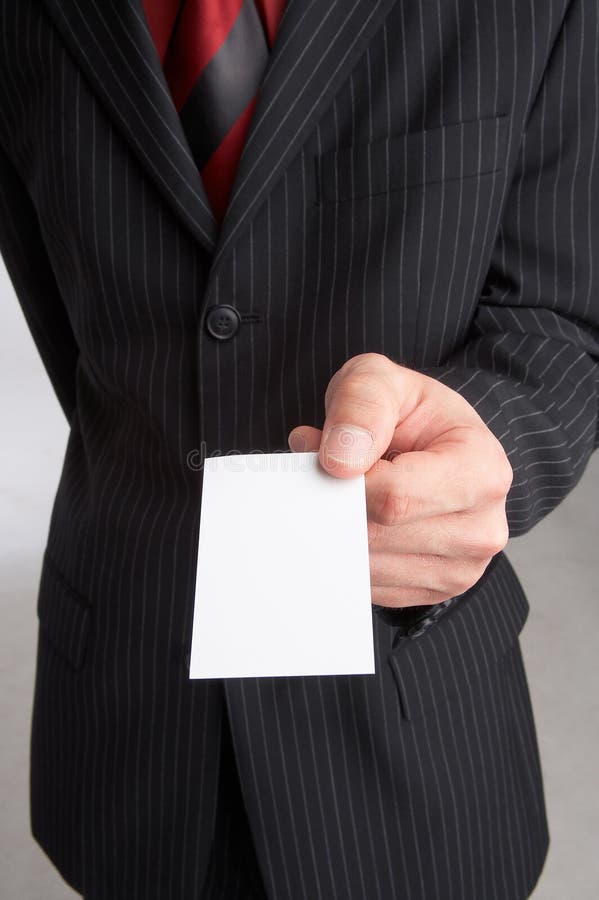ambitious businessman in his best suit holds a businesscard in a hand, introducing and presenting his company, introduction - formal presentation of a smart person before the interview. ambitious businessman in his best suit holds a businesscard in a hand, introducing and presenting his company, introduction - formal presentation of a smart person before the interview