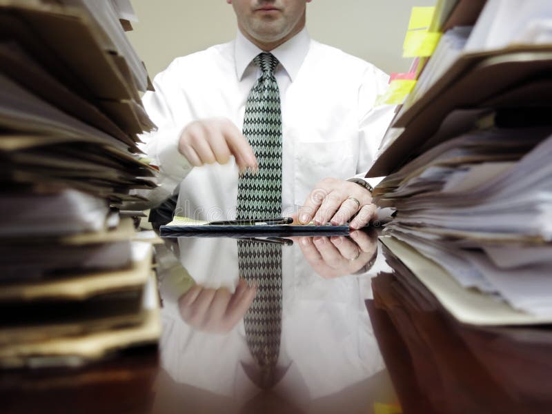 Zakenman bij Bureau met Stapels van Dossiers stock afbeelding Zakenman bij Bureau met Stapels van Dossiers stock afbeelding