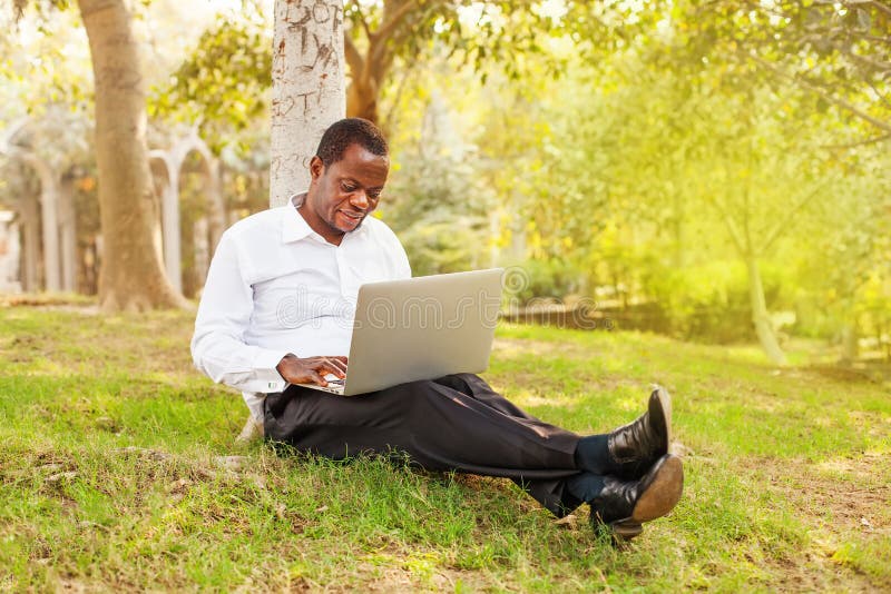 Zakenman die aan laptop in openlucht werkt royalty-vrije stock foto Zakenman die aan laptop in openlucht werkt royalty-vrije stock foto