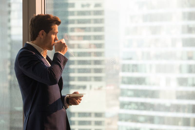 Zakenman die ochtend van koffie in bureau genieten royalty-vrije stock afbeeldingen Zakenman die ochtend van koffie in bureau genieten royalty-vrije stock afbeeldingen