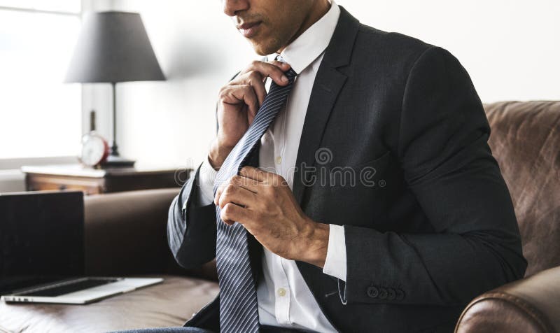 Zakenman die op een stropdas zetten stock afbeelding Zakenman die op een stropdas zetten stock afbeelding