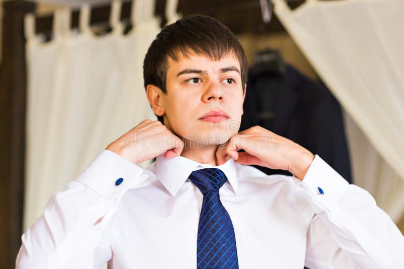 Zakenman die op een stropdas zetten stock foto's Zakenman die op een stropdas zetten stock foto's