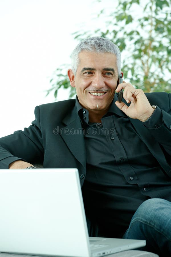 Zakenman die op mobiele telefoon spreekt stock afbeelding Zakenman die op mobiele telefoon spreekt stock afbeelding