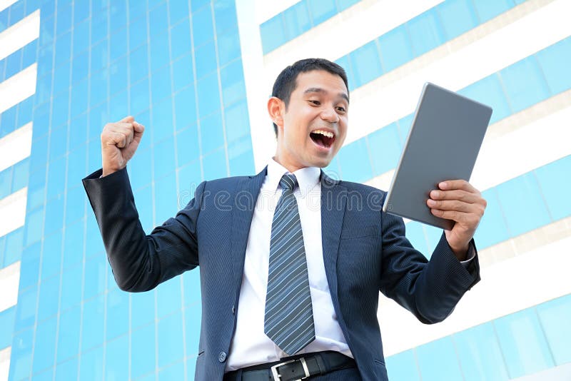Zakenman die zijn wapen opheffen terwijl het bekijken tabletcomputer stock foto's Zakenman die zijn wapen opheffen terwijl het bekijken tabletcomputer stock foto's