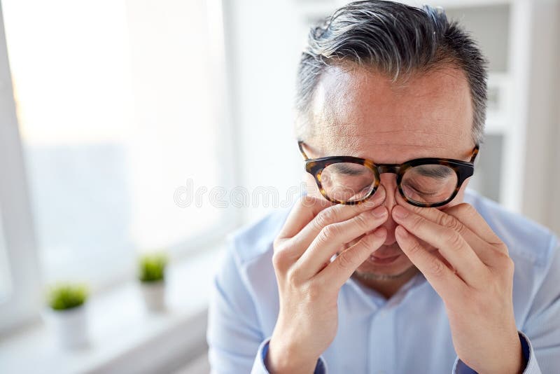 Zakenman in glazen die ogen wrijven op kantoor stock foto's Zakenman in glazen die ogen wrijven op kantoor stock foto's