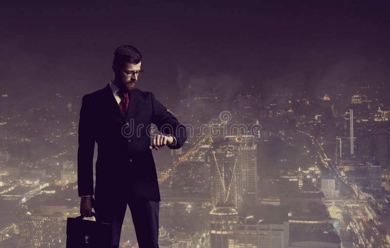 Zakenman met aktentas die zich over de achtergrond van de nachtstad bevinden stock foto Zakenman met aktentas die zich over de achtergrond van de nachtstad bevinden stock foto