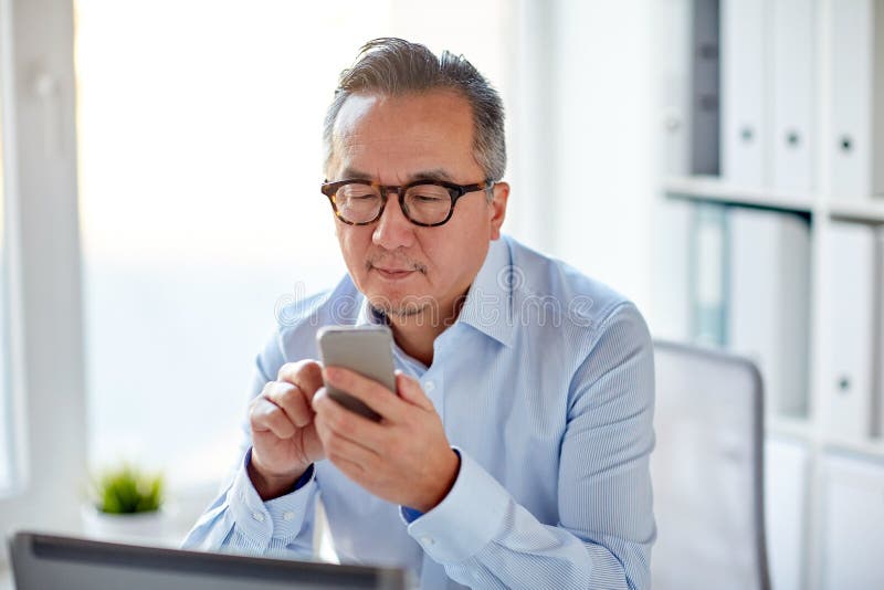 Zakenman met laptop het texting op smartphone stock foto Zakenman met laptop het texting op smartphone stock foto