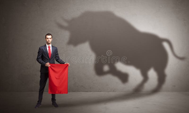 Businessman standing with red cloth in his hand and big bull shadow on the wall. Businessman standing with red cloth in his hand and big bull shadow on the wall