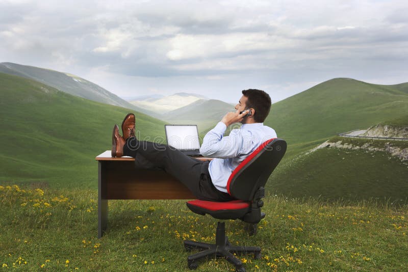 Zakeman die een mobiele telefoon gebruikt op een bureau in een veld stock afbeelding