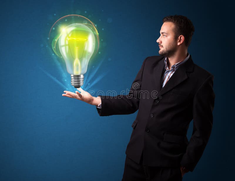 Zakenmanholding die lightbulb in zijn hand gloeien stock fotografie Zakenmanholding die lightbulb in zijn hand gloeien stock fotografie