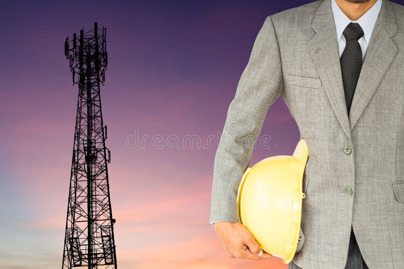 Zakenmaningenieur en telecommunicatietoren bij zonsondergang stock afbeelding Zakenmaningenieur en telecommunicatietoren bij zonsondergang stock afbeelding