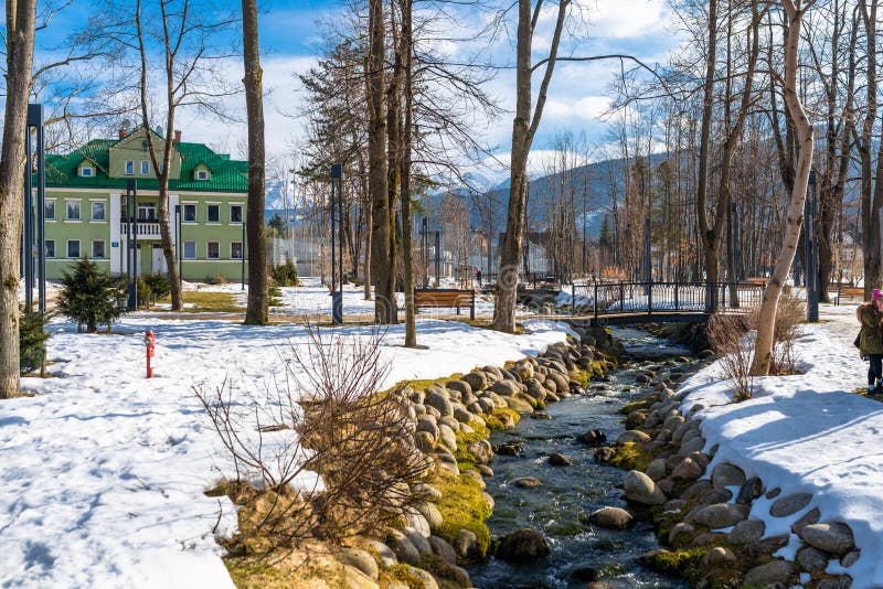 Zakopane, Polonia - 21 de febrero de 2019 Parque en la ciudad cubierta con la nieve con un verde, casa del ladrillo Árboles visib imagenes de archivo Zakopane, Polonia - 21 de febrero de 2019 Parque en la ciudad cubierta con la nieve con un verde, casa del ladrillo Árboles visib imagenes de archivo
