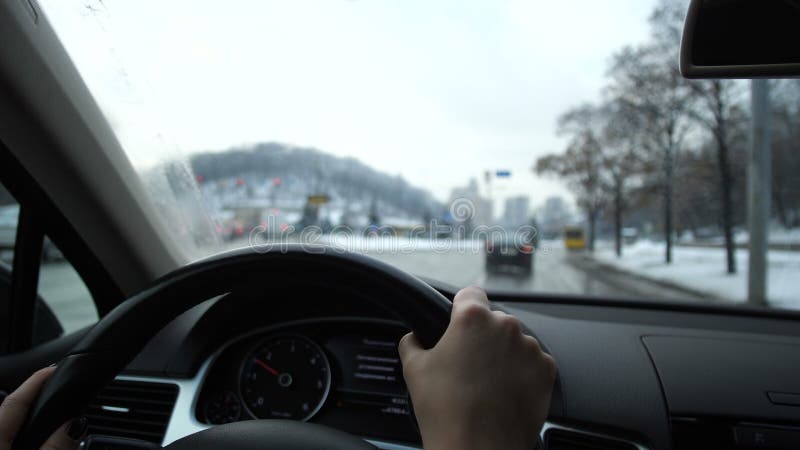 Zakończenie Kobiet ręki prowadzą samochód Na zewnątrz okno jest zimy miasto 4K zwalniają mo