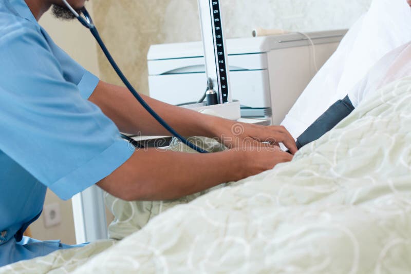 Zakończenie w górę męskiego pielęgniarki ręki czeka ciśnienia krwi metru z Sphygmomanometer pacjent kłaść na wygodnej klinice złe obrazy royalty free Zakończenie w górę męskiego pielęgniarki ręki czeka ciśnienia krwi metru z Sphygmomanometer pacjent kłaść na wygodnej klinice złe obrazy royalty free