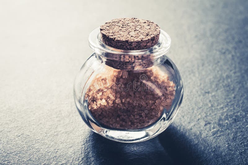 zakończenie Brown Surowy cukier W Małej Szklanej butelce Zamykającej Z Korkowym Stopper Na łupku kamieniu zdjęcia stock zakończenie Brown Surowy cukier W Małej Szklanej butelce Zamykającej Z Korkowym Stopper Na łupku kamieniu zdjęcia stock