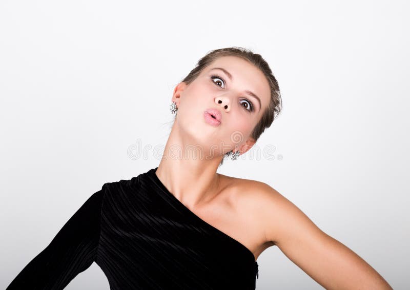 Zakończenie mody fotografii młoda dama w eleganckiej czerni sukni, figlarnie kobieta uśmiecha się lotniczego buziaka i wysyła zdjęcia stock Zakończenie mody fotografii młoda dama w eleganckiej czerni sukni, figlarnie kobieta uśmiecha się lotniczego buziaka i wysyła zdjęcia stock