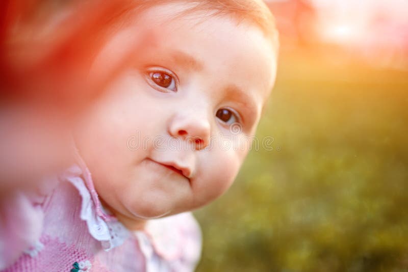 Zakończenie portret dziewczynka przeciw zielony łąkowy patrzeć do kamery outdoors w świetle słonecznym zdjęcie royalty free Zakończenie portret dziewczynka przeciw zielony łąkowy patrzeć do kamery outdoors w świetle słonecznym zdjęcie royalty free