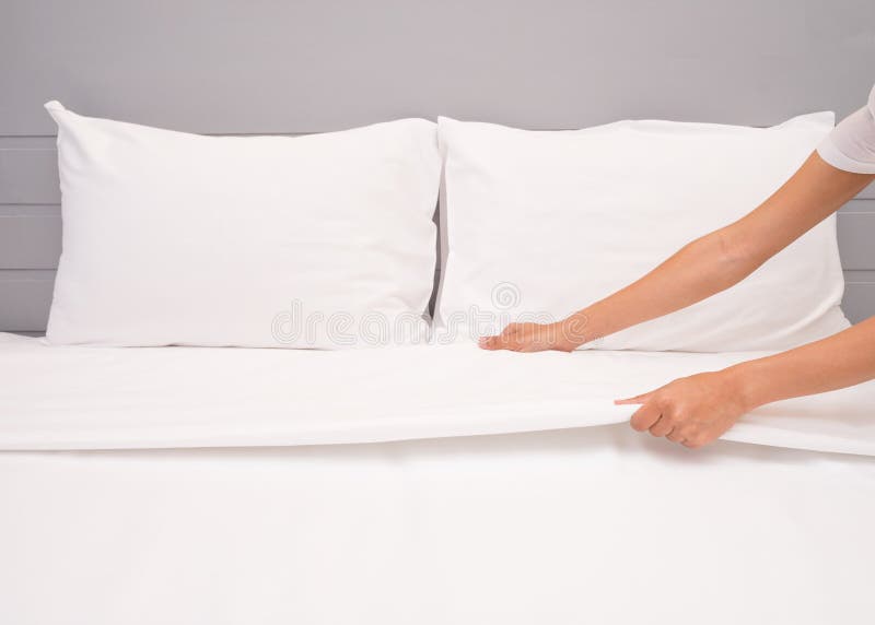 Zakończenie ręki up ustawiania biały łóżkowy prześcieradło w pokoju hotelowym