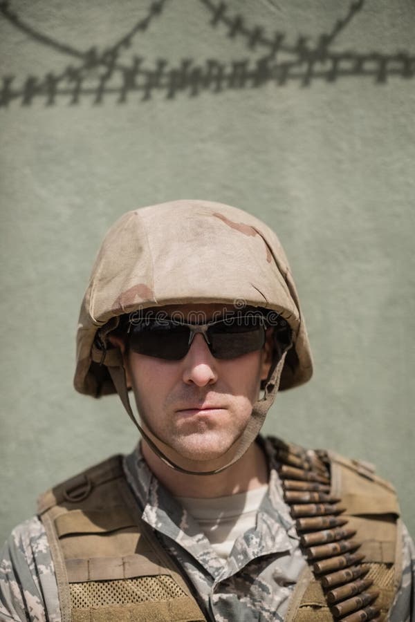 Zakończenie ufna militarna żołnierz pozycja przeciw betonowej ścianie zdjęcia stock Zakończenie ufna militarna żołnierz pozycja przeciw betonowej ścianie zdjęcia stock