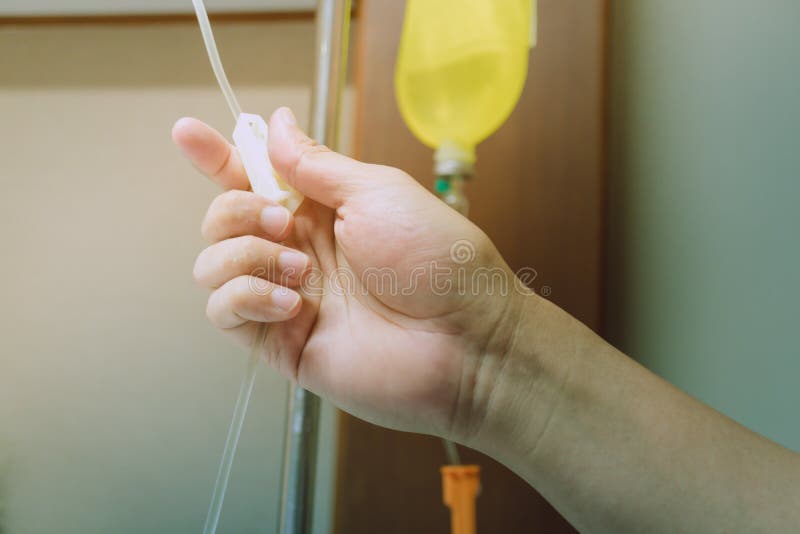 Zakończenie up ręka przystosowywa zasolonego IV kapinos dla pacjenta w szpitalu zdjęcia stock Zakończenie up ręka przystosowywa zasolonego IV kapinos dla pacjenta w szpitalu zdjęcia stock