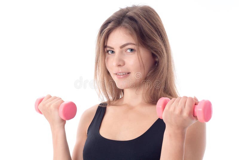 Zakończenie uśmiechnięta sporty dziewczyna która trzyma w ona ręki dwa dumbbells obraz royalty free Zakończenie uśmiechnięta sporty dziewczyna która trzyma w ona ręki dwa dumbbells obraz royalty free