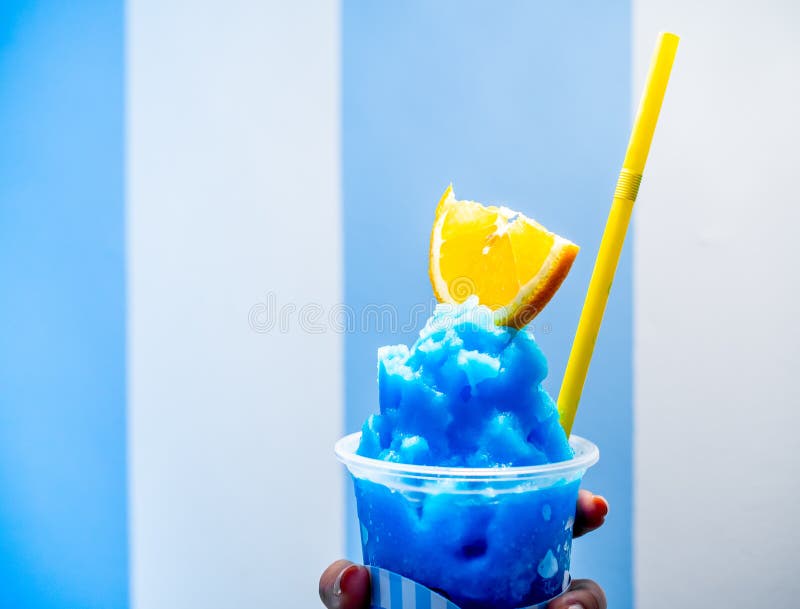 Zakończenie w górę świeżego błękitnego cytryny smoothie z pokrojonym żółtym wapnem i kolor żółty pije słomę w plastikowej filiżan obraz royalty free Zakończenie w górę świeżego błękitnego cytryny smoothie z pokrojonym żółtym wapnem i kolor żółty pije słomę w plastikowej filiżan obraz royalty free