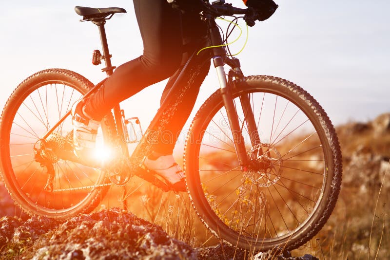 Zakończenie widok na cyklisty rowerzyście jedzie rower na sposobu widoku na tle wschód słońca spod spodu obraz stock Zakończenie widok na cyklisty rowerzyście jedzie rower na sposobu widoku na tle wschód słońca spod spodu obraz stock