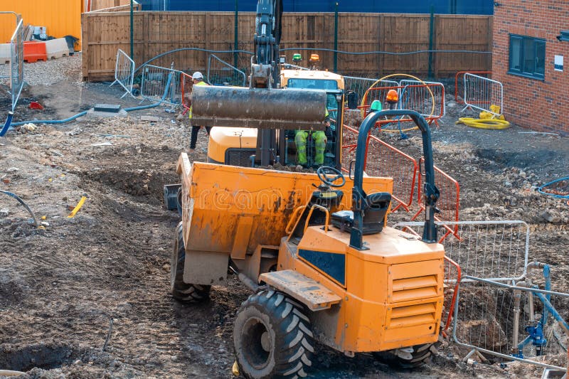 Construction plant and machinery. Dumper and excavator working on a new homes construction site. Construction plant and machinery. Dumper and excavator working on a new homes construction site