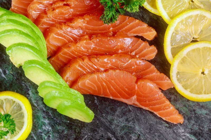 Zalm met citroen en avocado op marmeren plaat wordt gesneden die royalty-vrije stock foto Zalm met citroen en avocado op marmeren plaat wordt gesneden die royalty-vrije stock foto