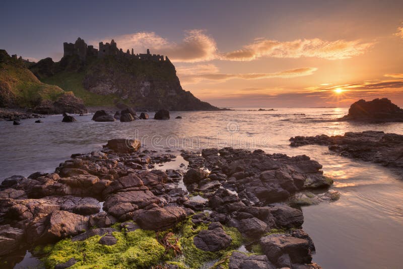 Zamek Dunluce w Irlandii Północnej o zachodzie słońca obraz stock Zamek Dunluce w Irlandii Północnej o zachodzie słońca obraz stock