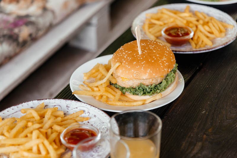 Zamknięcie pysznego burgera serowego na płycie z fryzurami francuskimi zdjęcie stock