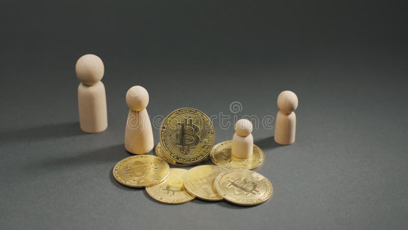 Zamknięcie złotych monet bitcoinowych i drewnianych figury na szarym tle. waluty cyfrowe btc cryptocurrency