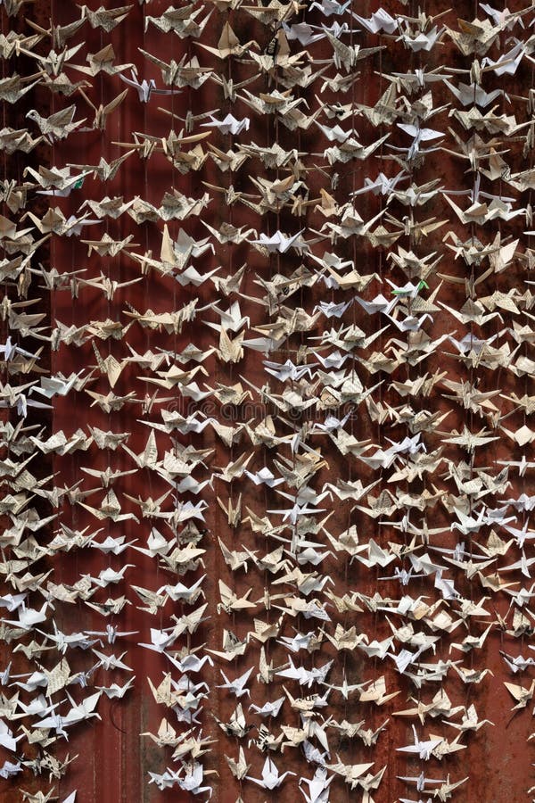 Zamknięty widok 1000 origami składający papierowi żurawie rzeźbi przeciw tłu starej czerwieni blaszany popierać kogoś zdjęcie royalty free Zamknięty widok 1000 origami składający papierowi żurawie rzeźbi przeciw tłu starej czerwieni blaszany popierać kogoś zdjęcie royalty free