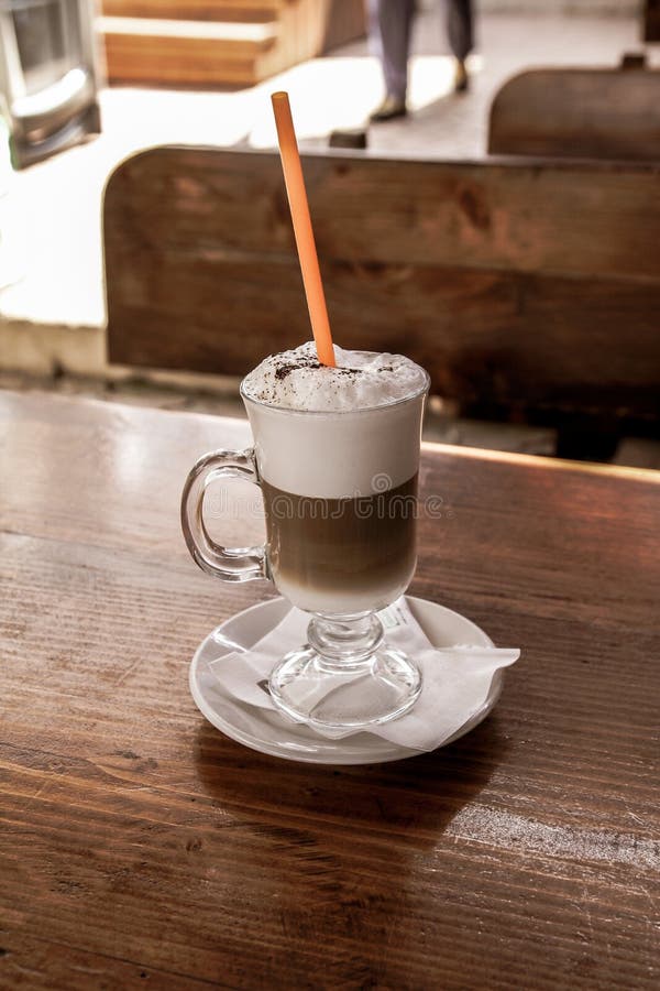 Zamyka w górę cukiernianego latte z słomą na drewnianym stole fotografia stock Zamyka w górę cukiernianego latte z słomą na drewnianym stole fotografia stock