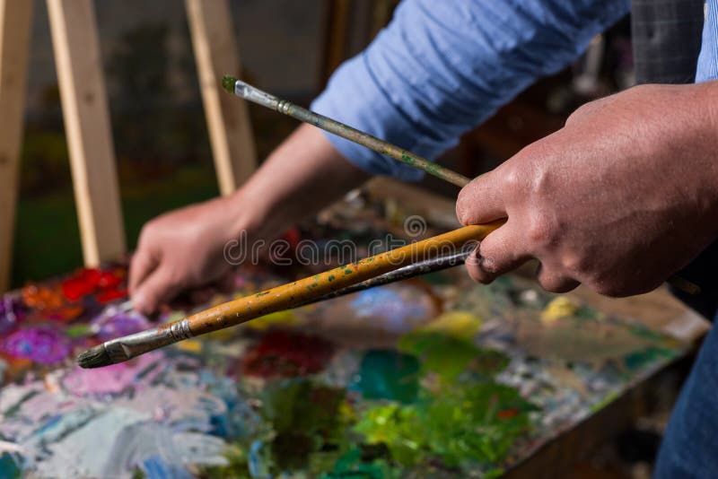 Zamyka w górę paintbrushes w artist& x27; s ręka obraz stock Zamyka w górę paintbrushes w artist& x27; s ręka obraz stock