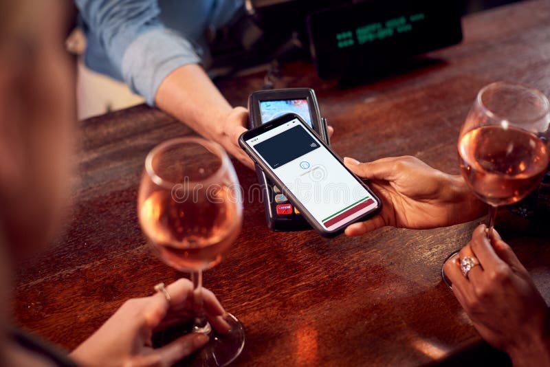 Zamykanie Płacących Za Drinki W Barze Za Pomocą Bezkontaktowej Aplikacji Na Telefonie Komórkowym zdjęcie stock Zamykanie Płacących Za Drinki W Barze Za Pomocą Bezkontaktowej Aplikacji Na Telefonie Komórkowym zdjęcie stock