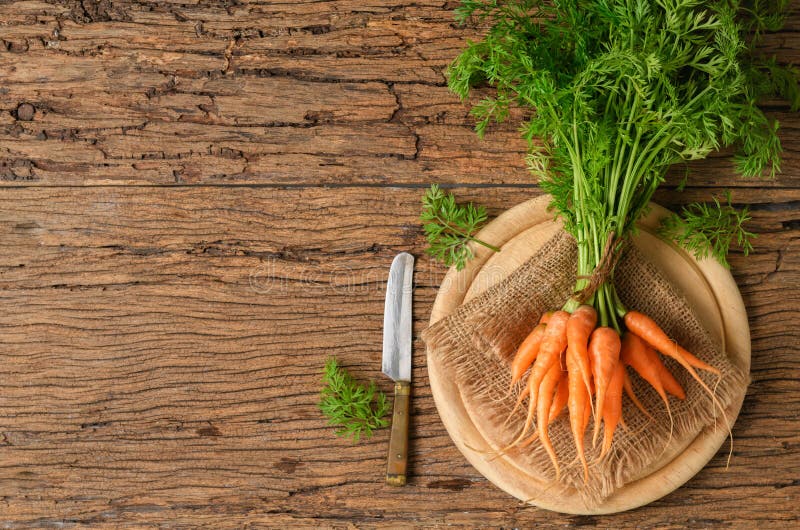 Zanahorias orgánicas frescas con las hojas verdes en la madera vieja fotografía de archivo libre de regalías Zanahorias orgánicas frescas con las hojas verdes en la madera vieja fotografía de archivo libre de regalías