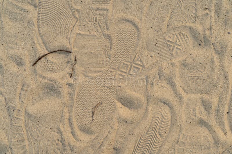 Zand op het strand met voetafdrukken en schoenen Vele voetafdrukken met schoenen en zonder schoenen stock afbeeldingen Zand op het strand met voetafdrukken en schoenen Vele voetafdrukken met schoenen en zonder schoenen stock afbeeldingen