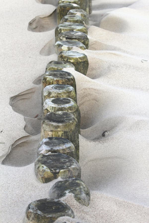 Zandig strand die een golfbreker en een duin tonen royalty-vrije stock foto Zandig strand die een golfbreker en een duin tonen royalty-vrije stock foto