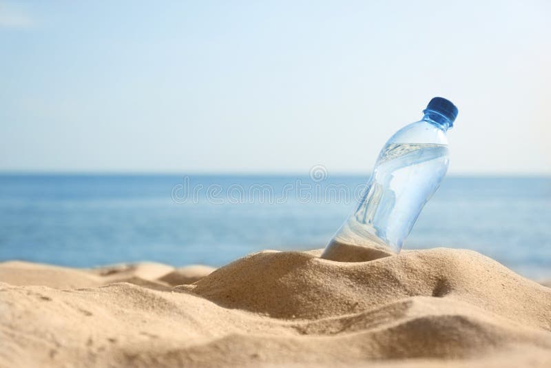 Zandig strand met fles het verfrissen van drank op hete de zomerdag stock afbeelding Zandig strand met fles het verfrissen van drank op hete de zomerdag stock afbeelding