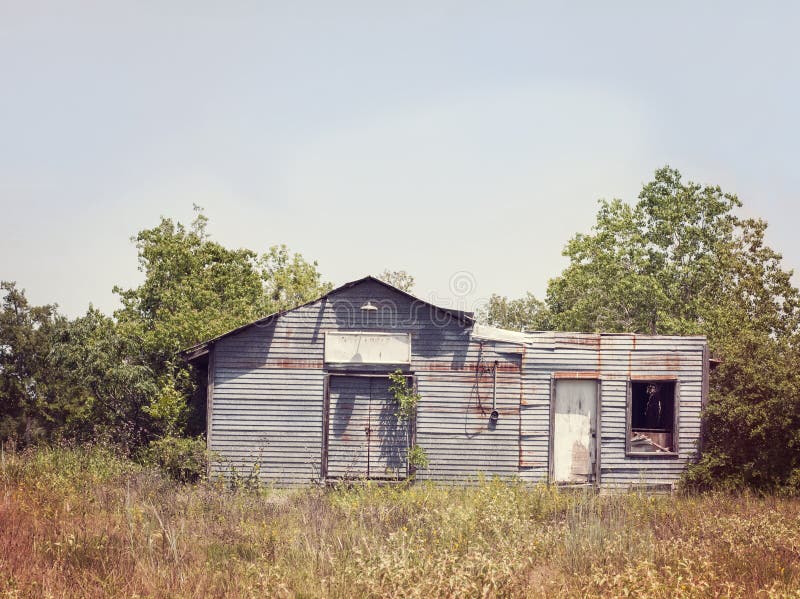 Derelict abandoned metal shed in an overgrown field. Derelict abandoned metal shed in an overgrown field