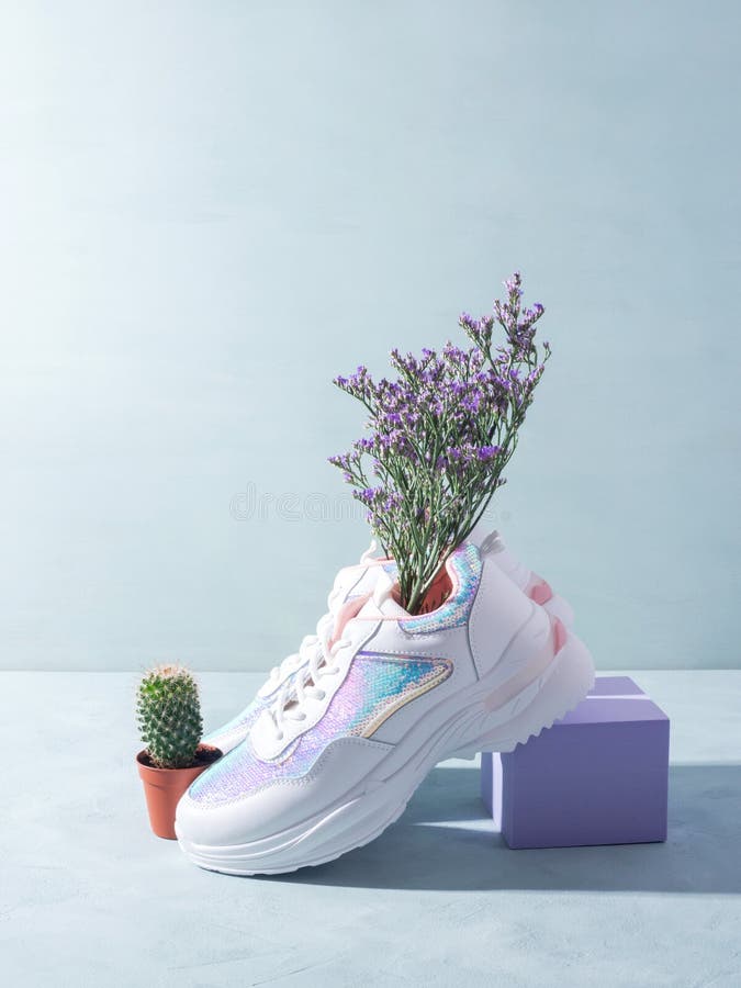 Retocar Tiza Consentimiento Zapatillas Blancas Con Flores Sobre Fondo Azul Con Podio Cubo Imagen de  archivo - Imagen de cubo, brillante: 226419713